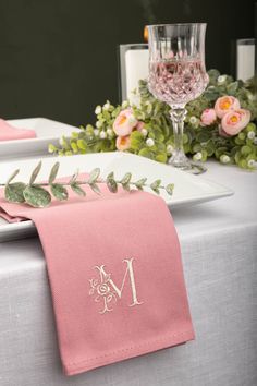 the table is set with pink napkins and place settings