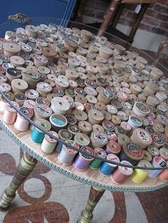 a table that has many spools of thread on it