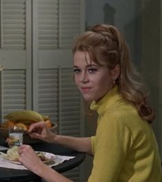 a woman sitting at a table eating food