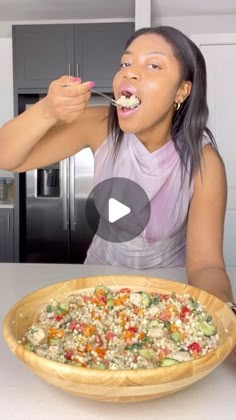 a woman eating food out of a wooden bowl