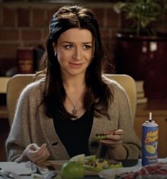 a woman sitting at a table with food in front of her