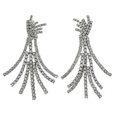 Embodying the epitome of luxury, the Platinum 22.00cttw Pendant Diamond 7 Row Tassel Earrings are a testament to the mastery of fine jewelry craftsmanship, offering a breathtaking fusion of design, precision, and sheer magnificence. Adorn yourself with this extraordinary pair, and revel in the radiant allure that only such a spectacular piece can bring to your jewelry collection. The earrings boast a unique design with a pendant-style arrangement, where seven rows of resplendent diamonds cascade Diamond Chandelier, Pendant Diamond, American Modern, Round Cut Diamond, Tassel Earrings, Timeless Elegance, Metallica, The Row, Unique Design