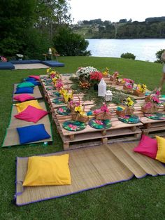 an outdoor picnic with lots of food and flowers on the table set up for people to eat