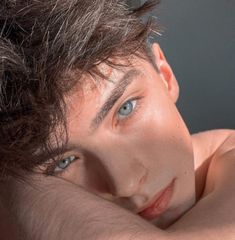 a young man with blue eyes posing for the camera