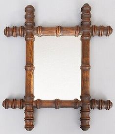 an old wooden frame mirror with wood posts