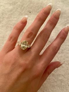 a woman's hand with a ring on top of her finger and two diamonds in the middle