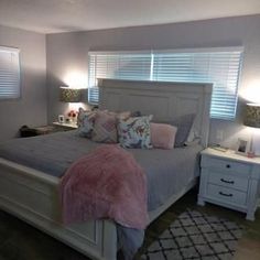 a bedroom with a bed, nightstands and two lamps