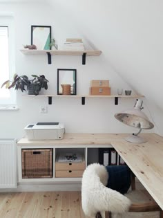 a desk with some shelves above it and a chair in front of the desk area