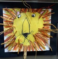 an art project made out of sticks and paper with a lion's face on it