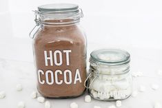 a jar filled with hot cocoa and marshmallows sitting next to it's lid