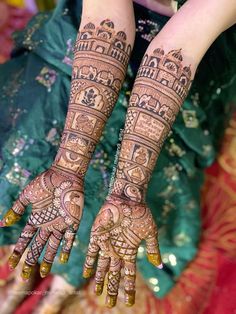 two hands with henna tattoos on them