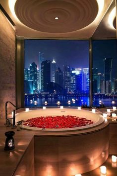 a large bath tub sitting in the middle of a bathroom next to a big window