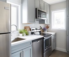 a kitchen with stainless steel appliances and white counter tops