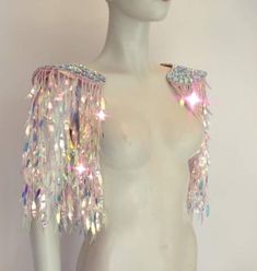 a white mannequin with multicolored sequins on it's arms