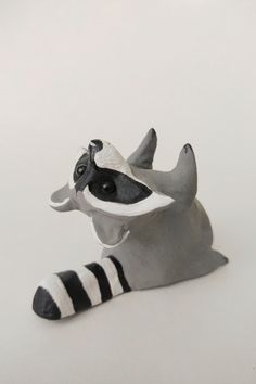 a raccoon figurine is sitting on the floor