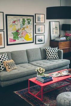 a living room filled with lots of furniture and pictures on the wall above it's coffee table