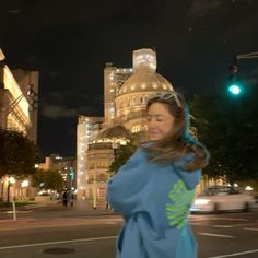 a woman standing in the middle of a street at night