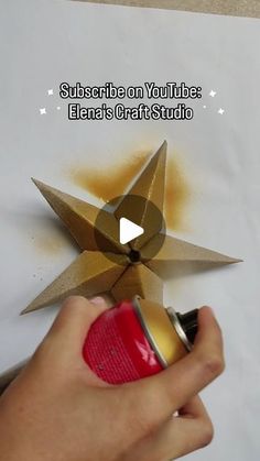 someone is using a spray can to paint an origami star on a piece of paper