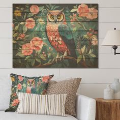 an owl painted on the side of a wall next to a white couch and lamp