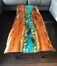 a coffee table made out of wood with blue water running down it's sides