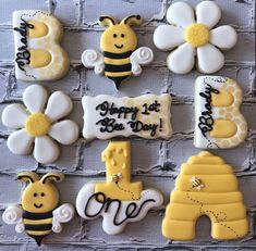 decorated cookies are arranged in the shape of bee's and honeybees on a brick wall