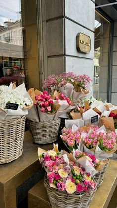 baskets filled with flowers sitting on top of a wooden table