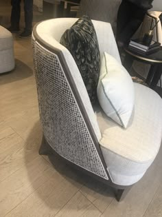 a white chair with two pillows on it