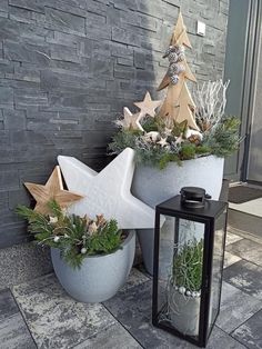 two cement planters with plants in them next to a brick wall and lantern light