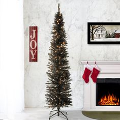 a decorated christmas tree in front of a fireplace