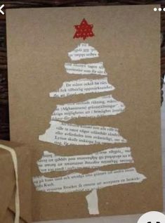 a christmas tree made out of brown paper on top of a table next to a card