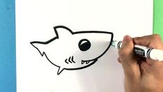 someone is drawing a cartoon shark on paper