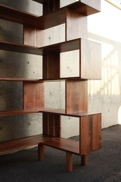 a wooden shelf sitting on the side of a wall next to a cement wall and concrete floor