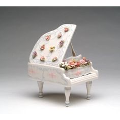 a miniature white piano with flowers on it