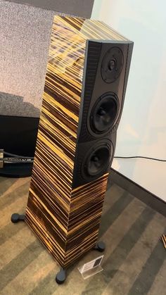 two speakers sitting on top of a wooden floor