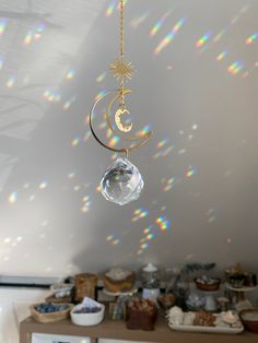 a sun and moon mobile hanging from a ceiling in a room filled with other items