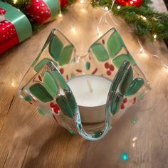 a glass candle holder sitting on top of a wooden table