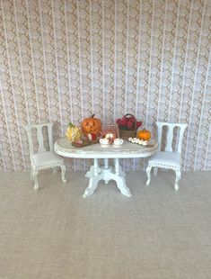 a doll house table and chairs with pumpkins on them