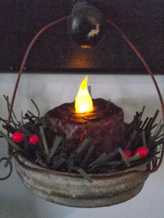 a candle is lit in a basket with greenery