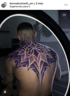 the back of a man with tattoos on his body