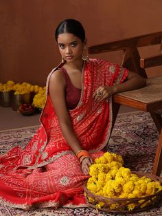 This exquisite saree is a true celebration of India's rich textile heritage, combining three iconic crafts from different regions. The base of the saree is handwoven in Banaras, showcasing the intricate beauty of Banarasi weaving with its luxurious texture and fine craftsmanship. The saree is then adorned with the timeless art of Bandhani, created by skilled artisans in Bhuj, where each dot is carefully tied and dyed to produce vibrant, delicate patterns. To complete this masterpiece, artisans i Gotta Patti, Wedding Designer, On The Border, Red Saree, Timeless Art, Silk Saree