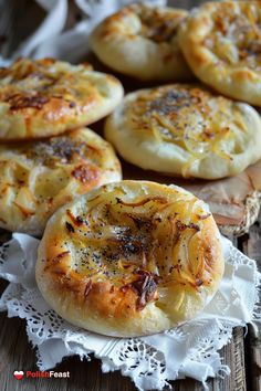 several small pizzas sitting on top of a white doily