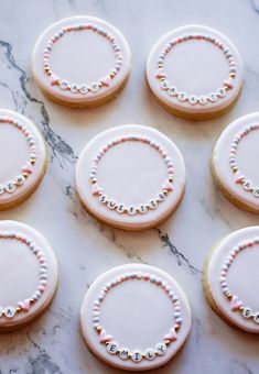 six decorated cookies sitting on top of a marble counter