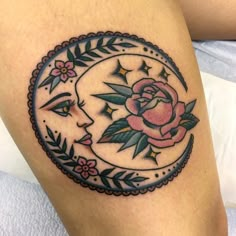 a woman's thigh with a rose and moon tattoo on it