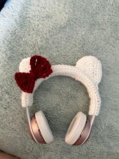 a pair of headphones with a knitted heart on them sitting on a blanket