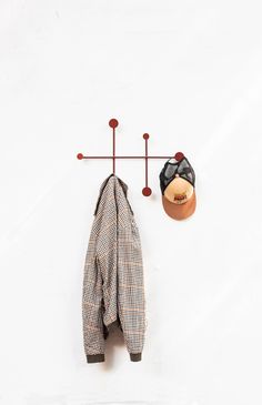 a coat rack and hat hanger on a white wall next to a pair of shoes