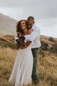 a man and woman hugging each other in a field