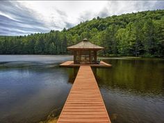 a wooden dock sitting on top of a lake next to a forest