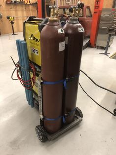 two propane tanks are stacked on top of each other in a garage with tools nearby