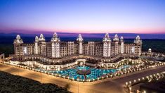 an aerial view of the resort at night with its lights on and pool in front