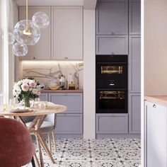 a kitchen with grey cabinets and marble counter tops, an oven in the wall and a dining table set for four